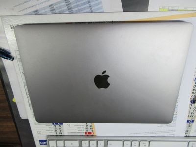 un ordinateur portable Apple argenté posé sur un bureau