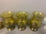 four glass vases sitting on a table next to each other