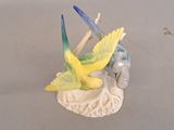 a figurine of a bird sitting on a shell