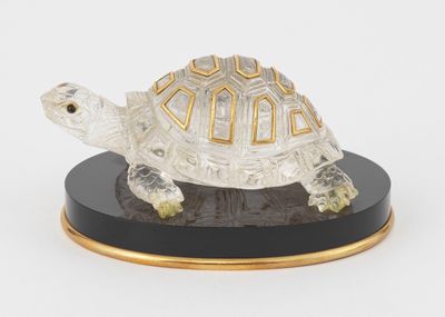 figurine représentant une tortue sur un socle noir, sur fond blanc
