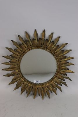 un miroir doré en forme d'étoile accroché au mur