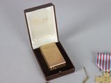 a small box with a gold medal and a red, white, and blue ribbon