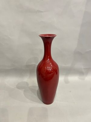 a red vase that is sitting on a white surface
