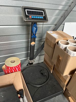 a scale that is next to some boxes and a roll of toilet paper