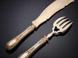 paire de couverts composée d'un couteau et d'une fourchette posés sur un fond noir