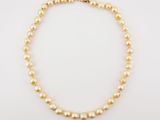 a pearl necklace with a gold clasp on a white background