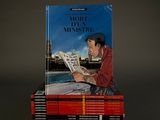books stacked on top of each other with a man reading a newspaper