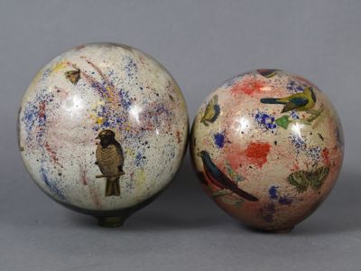 deux vases ornés d'oiseaux, posés l'un à côté de l'autre sur une surface grise
