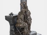 statue of a woman sitting on a chair with a man kneeling next to her