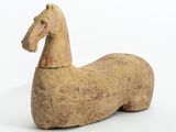 un cheval de bois posé sur une surface blanche