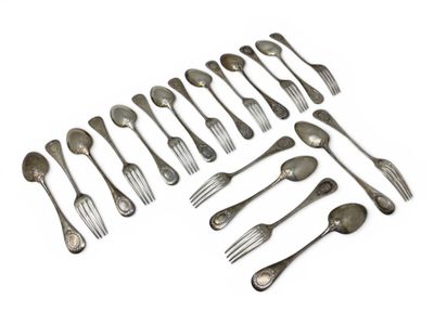 many forks and spoons laid out on a white surface