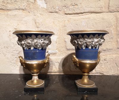 deux vases posés sur une table, avec un mur de pierre en arrière-plan