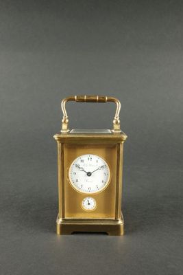 une image représentant une horloge dorée munie d'une manivelle, sur fond gris