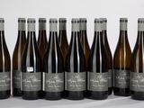 six bouteilles de vin sont alignées sur une surface blanche