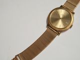 an image of a gold watch on a white surface