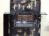 une armoire noire ornée d'un motif noir et or