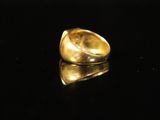 a close up of a gold ring on a black surface