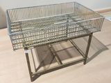 stainless steel wire basket on a metal stand on a wooden floor