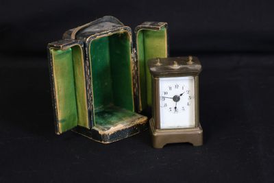 a small clock inside of a green case on a black background