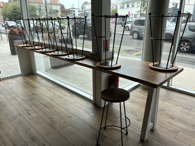 une longue table avec plusieurs chaises devant une fenêtre