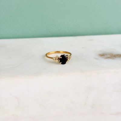 a close up of a gold ring with a black stone on it