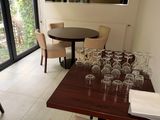une salle à manger avec une table et des chaises, et une table sur laquelle sont posés des verres à vin