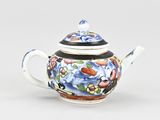 a blue and white teapot with a black lid