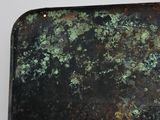 a close up of a piece of metal with green paint on it