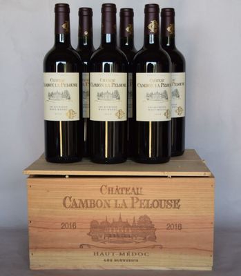 quatre bouteilles de vin rouge dans un coffret en bois posé sur une table