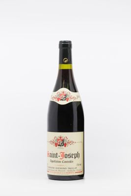 a bottle of wine sitting on top of a white table