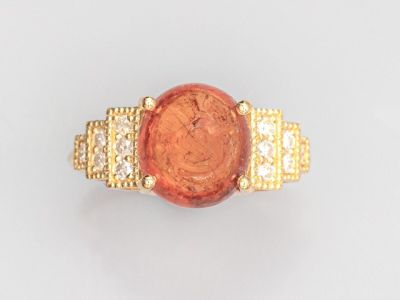 une image représentant une bague en or sertie d'une pierre rouge et de diamants
