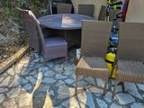 une table et des chaises, avec des skis posés dessus, devant un parasol