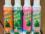 Trois vaporisateurs de « Tropical Fresh » sont alignés sur une table