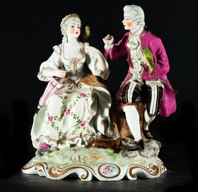 une figurine représentant un homme et une femme assis sur un banc