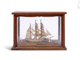 une petite maquette de bateau en bois exposée dans une vitrine