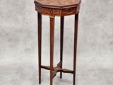 une petite table ronde avec un plateau en bois sur fond gris