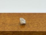 a close up of a single diamond on a wooden surface