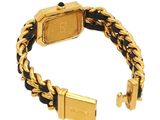 a close up of a gold and black bracelet with a gold clasp