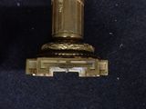 a gold clock that is on display on a blue surface
