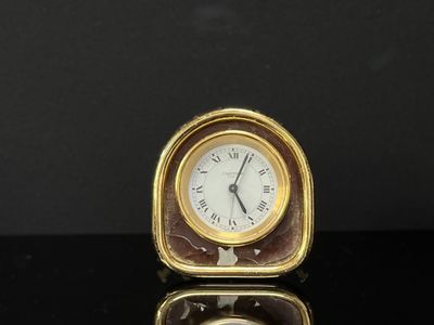 une petite horloge posée sur une table noire