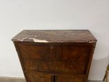 a small wooden cabinet with a marble top on the floor