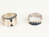 two silver rings sitting next to each other on top of a white surface