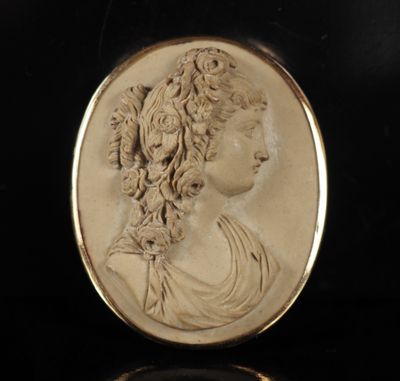 a close up of a gold plated medallion with a woman ' s face