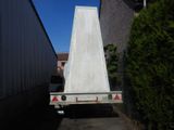 a white flatbed truck parked next to a building