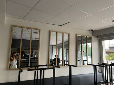 trois miroirs accrochés au mur d'un restaurant