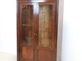 a wooden cabinet with a glass door on wheels