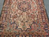 Un tapis persan ancien est posé sur le sol d'une pièce.