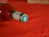 a bottle of wine sitting on a red cloth