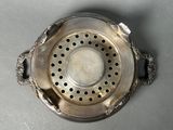 a metal strainer with holes in it on a table