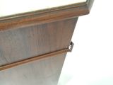 un gros plan d'une armoire en bois sur laquelle se trouve une horloge